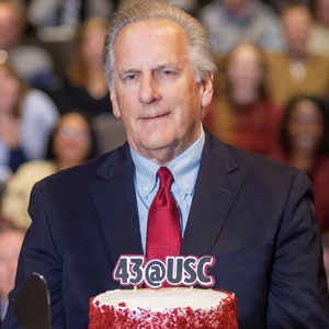 A portrait of Dennis Pruitt with cake.