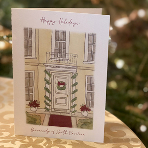 photo of a holiday card depicting a front door with decorations and the words Happy Holidays University of South Carolina on it 