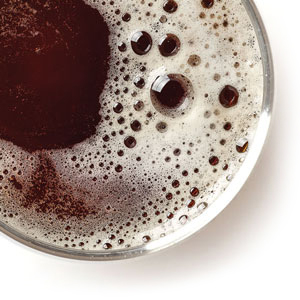 A bird’s eye view of a dark beer in a pint glass.