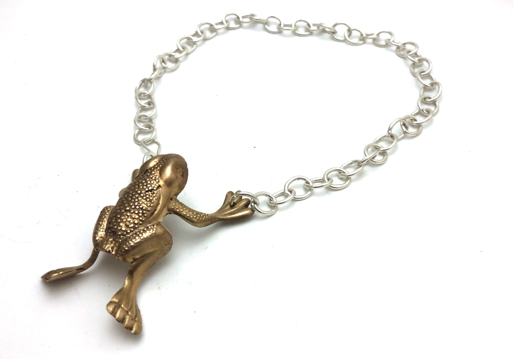 Piece of jewelry with a frog charm on it made by a USC student.