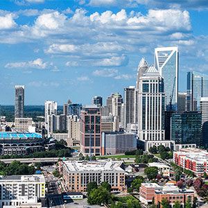 Charlotte city skyline with tall buildings and a blue sky.