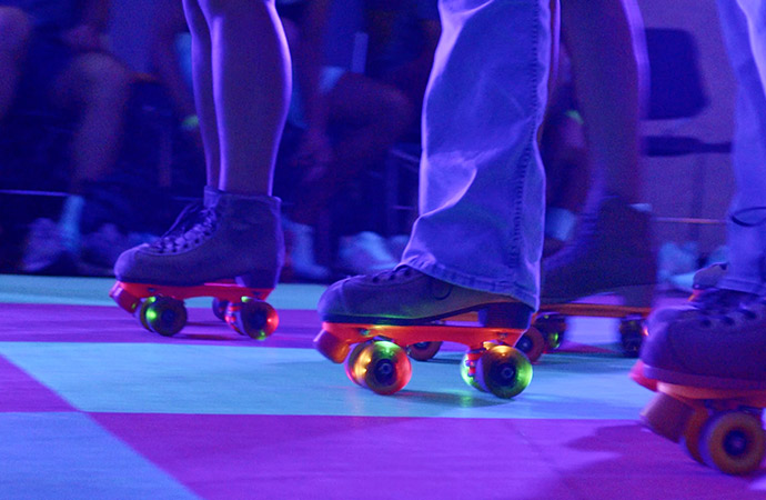 Three sets of roller skates with neon lights.