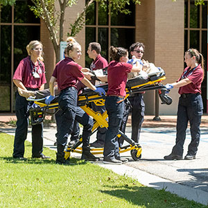 EMT students transport patient to ambulance