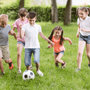 Young kids actively playing soccer.