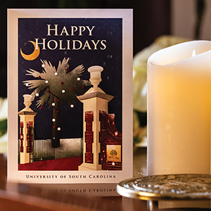 The 2023 holiday card sits by candles in the President's House
