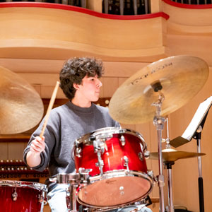 Freshman performance jazz major Allwyn Edwards plays the drums in the swing shift big band.
