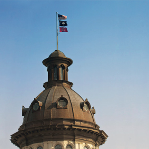 SC Statehouse dome with U.S., SC and USC flags flying atop it