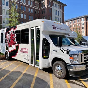 White bus with the USC Gamecocks logo and the words "University of South Carolina" on the side