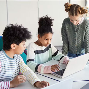 Three children looking at a laptop