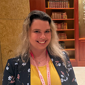 woman stands in front of library shelves with books