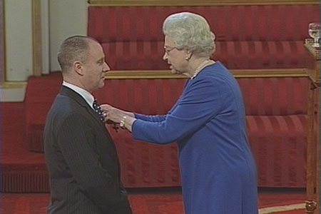 Gary Mason receiving award from Queen Elizabeth