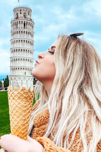 Abby Gerwit holding an ice cream cone below the leaning tower of Pisa. 