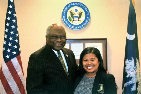 amelia wilks and U.S. Rep. Jim Clyburn are flanked by the U.S. and S.C. flags with the seal of the house of representatives above their heads