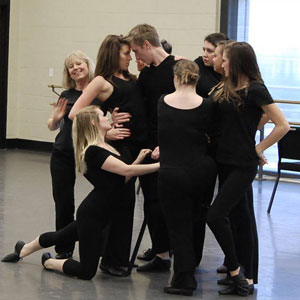 group of people dressed in black rehearsing acting, music