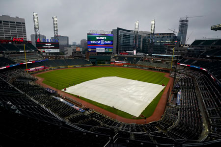baseball diamond in Truist Park in Atlanta with rain tarp in place and view of skyline in background