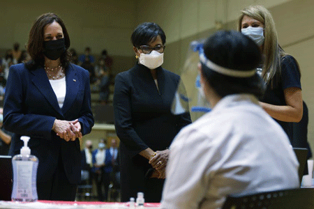 Vice President Kamala Harris stands in front of a health care professional with two other women at a pop-up vaccination clinic in Greenville, SC