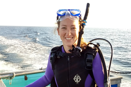 photo of Erin Meyer-Gutbrod on a boat in scuba gear with the ocean in the background