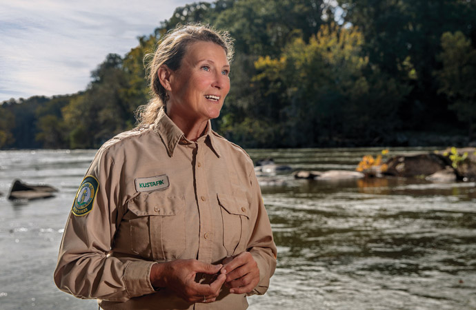 Portrait of Karen Kustafik standing in front of a river.