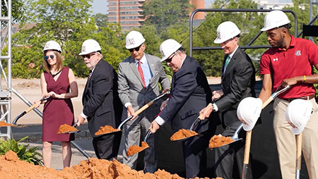 University and city leadership holding shovels for the ceremonial grounbreaking for the Campus Village project.