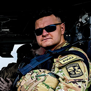 Jack Sadle wearing a military uniform sitting in a helicopter.