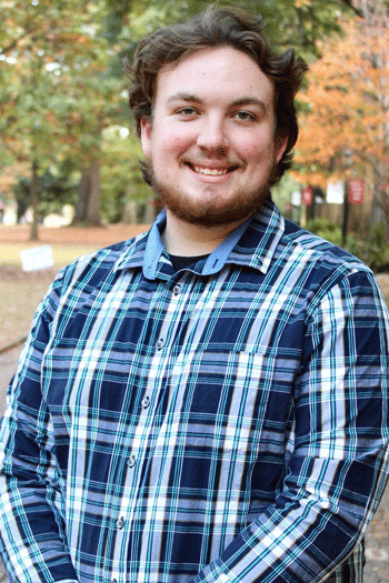 Student Cody Markow with a beard and wearing a blue plaid shirt