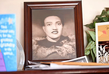 A black and white photo of Henrietta Lacks in a brown frame, sits in the living room of her grandson, Ron Lacks, in Baltimore, Maryland