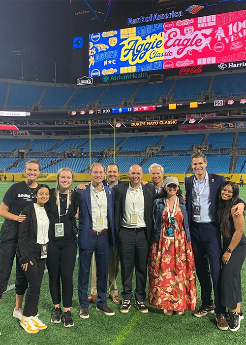 Group of UofSC alumni standing on the football field with professor Danny Morrison.