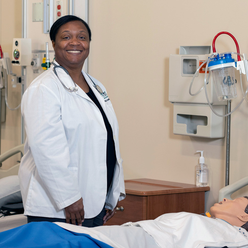 felicia jenkins wears a white medical coat in the nursing simulation lab at USC Upstate