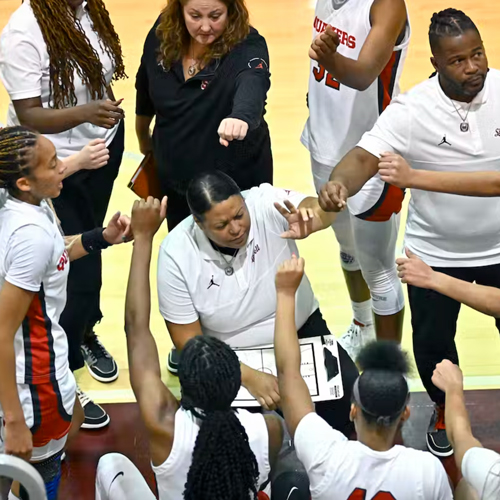Basketball players and coaches form a huddle