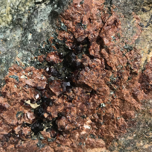 A close-up image of garnet inside of a rock at Santa Catalina, California.