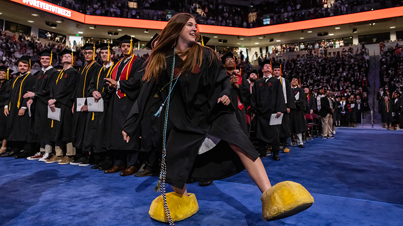 Woman  wearing the Cocky feet at graduation and running around to 2001.