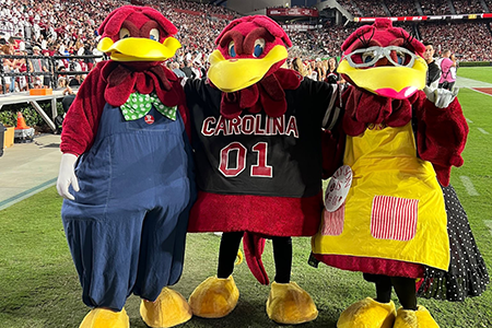 Sarah and her parents dressed in Cocky suits at Williams Brice Stadium