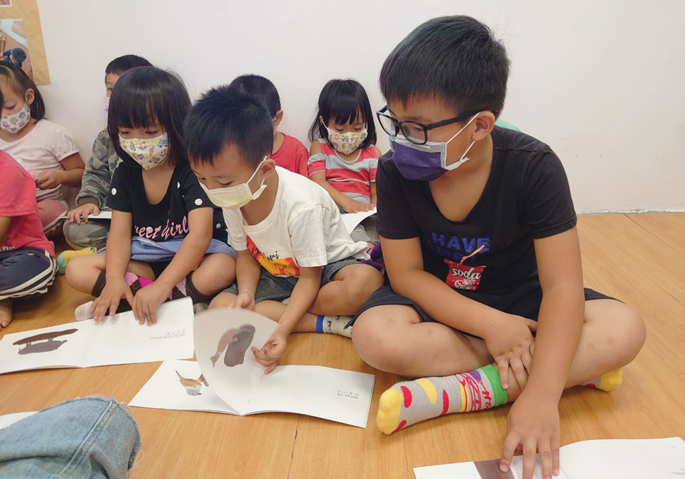 Taiwanese children look at books with the Atayal language.