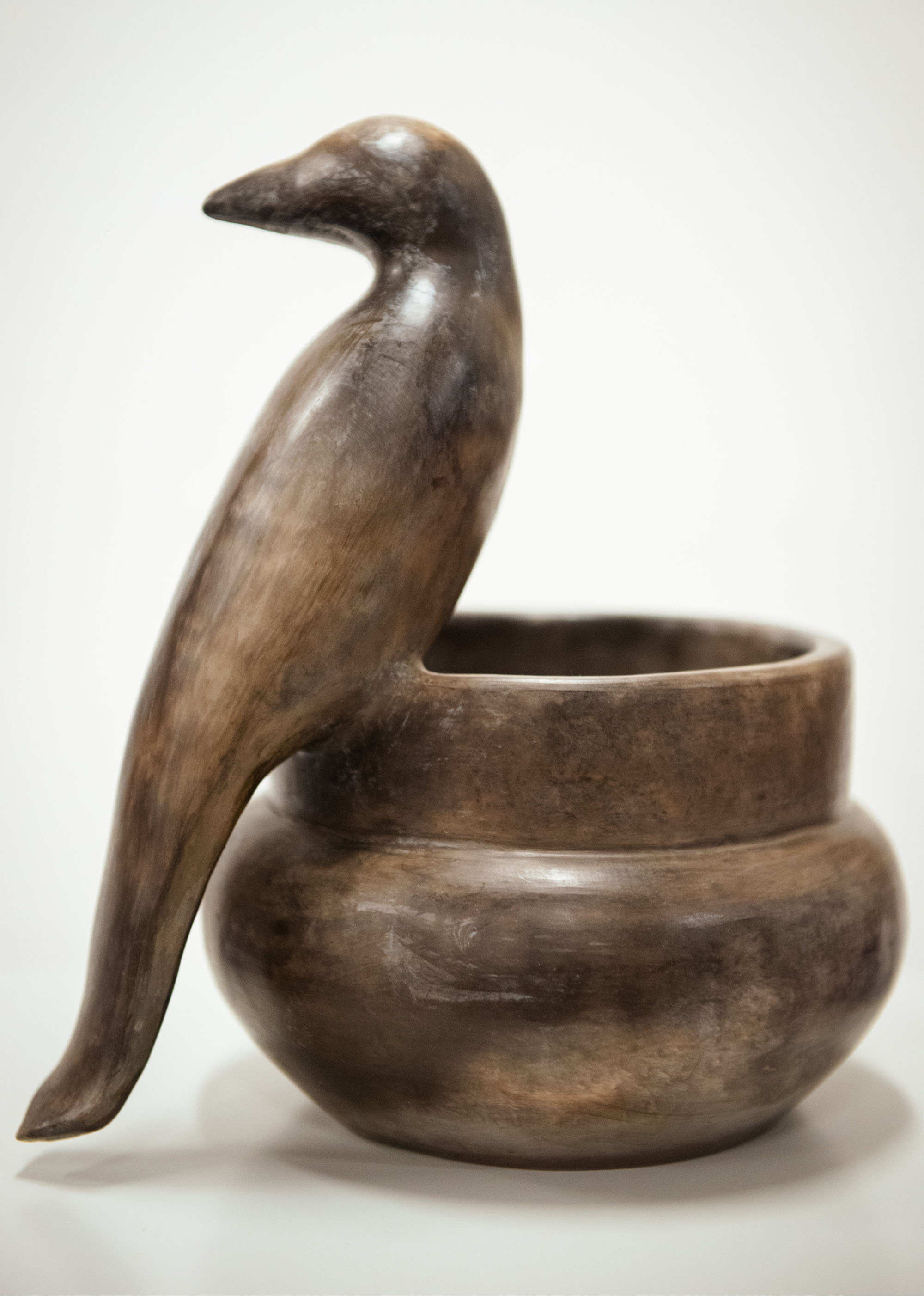 Catawba pottery bowl with a carved bird sitting on the left of the bowl