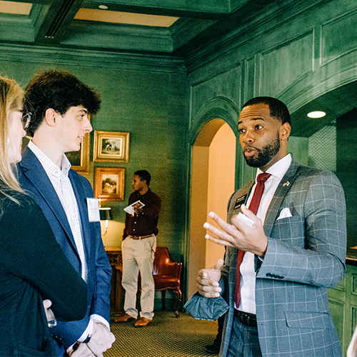 Marcus Fogle talks to attendees at the 2023 Atlanta alumni reception