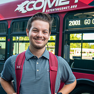 Blake Gibbons standing in front of a Comet bus.