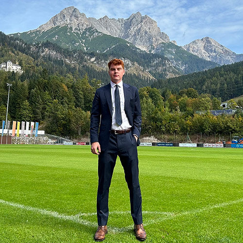 Henry Adam Caver stands on a soccer field in the Austrian alpss