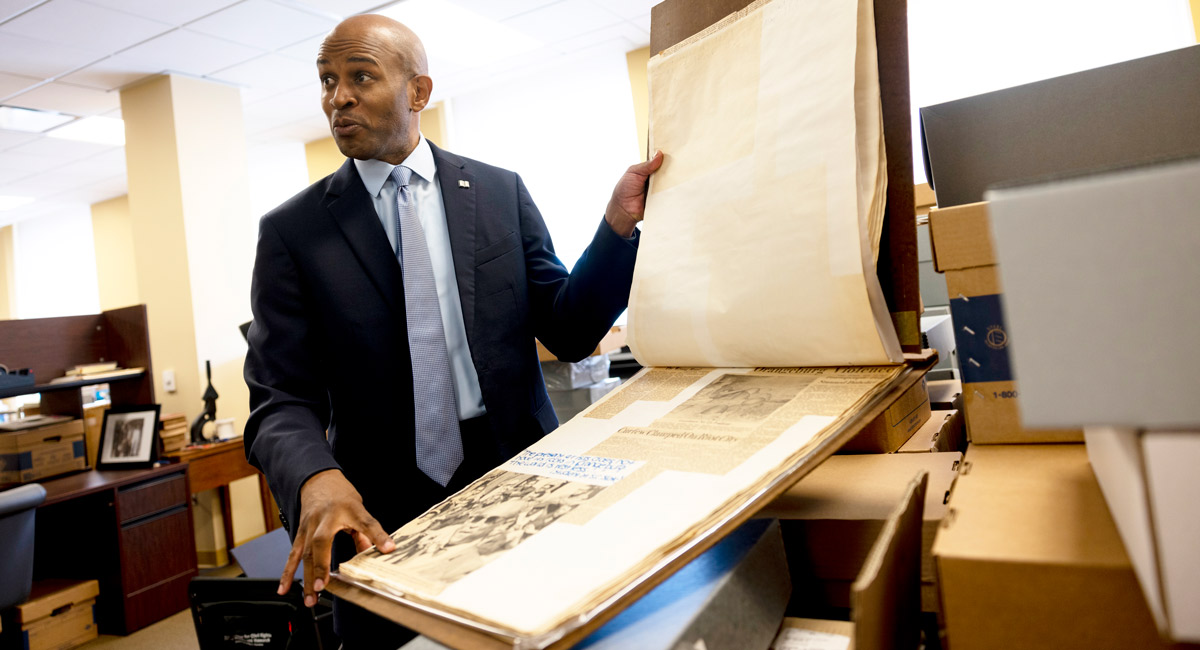 Bobbay Donaldson flips through a large scrapbook