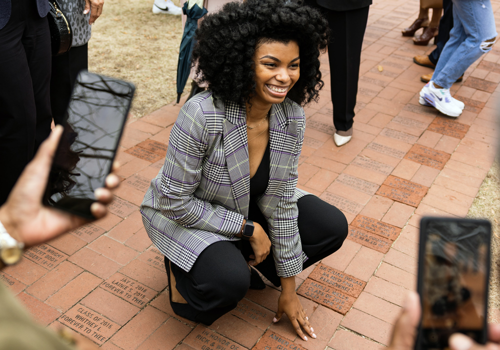 Amber Guyton kneels over her brick and smiles