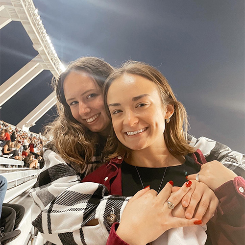 Holly Poag and a friend hug in the upper deck of Williams-Brice Stadium.