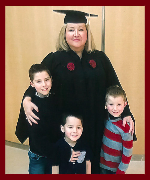 Sandra Edwards, posing with her grandchildren, celebrates graduating with a master's degree from the Darla Moore School of Business.