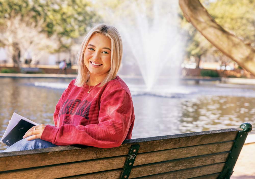 Kinsley King sits on a bench outside of Thomas-Cooper library.
