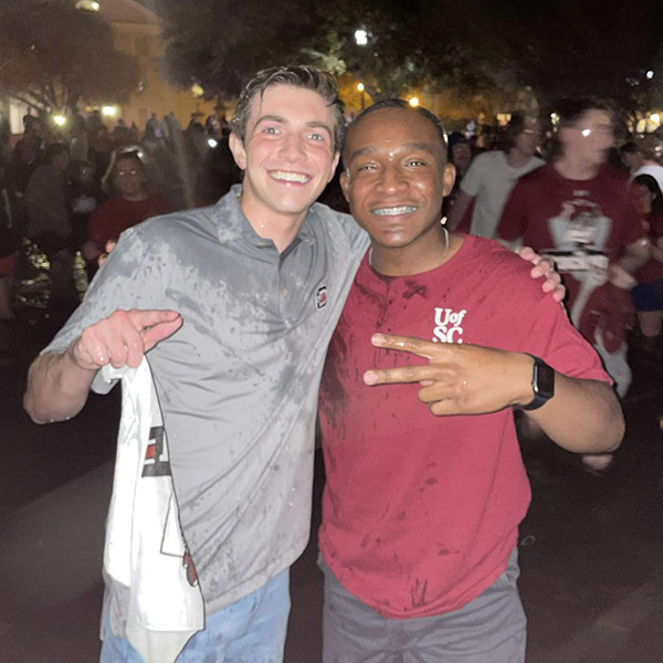 Jaheem McLaurin with a friend in the fountain after the women's basketball team won the 2022 national championship..