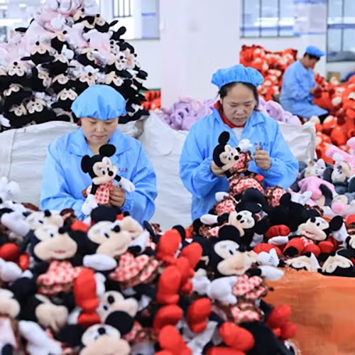 Factory workers sort plush dolls.