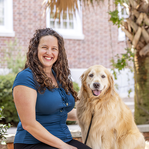 Eilea Knotts poses with her golden retriever service dog on campus.