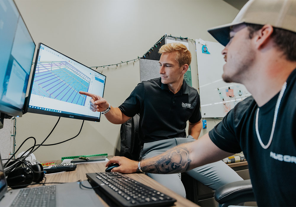 two men look at a computer screen