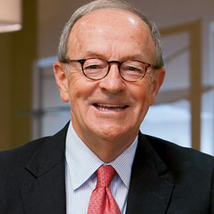 head and shoulders photo of a man with windows in the background