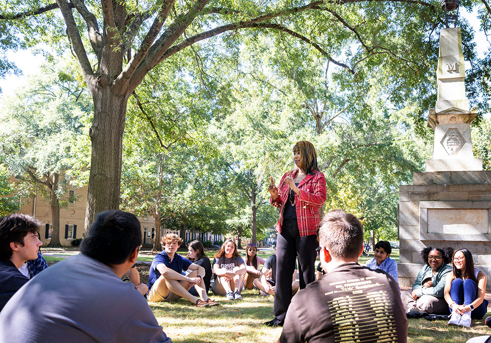 students sitting in a circle with professor in middle at class on the Horseshoe