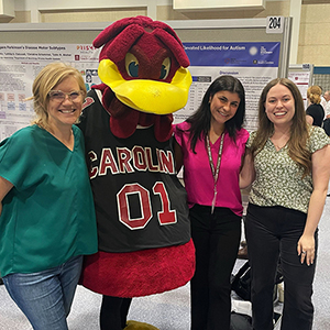 Four people pose with the Cocky mascot at Discover USC.