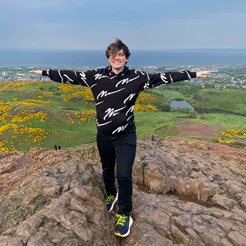 Rowan Coutsos staning on top of Arthur's Seat in Edinburgh, Scotland.